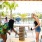 two women playing jenga under a cabana