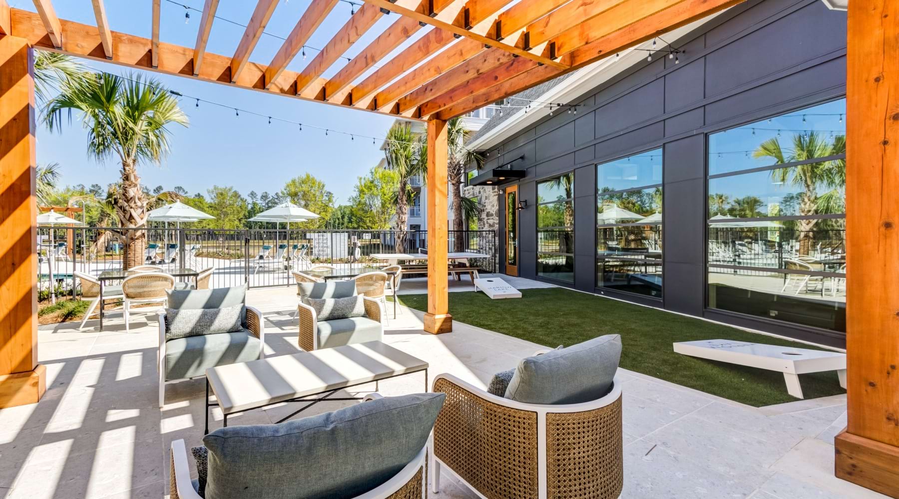 Outdoor Cabana Cabana with lounge chairs and cornhole boards at Marion Lake apartments in Savannah, GA