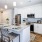 Room with kitchen appliances and an island with chairs