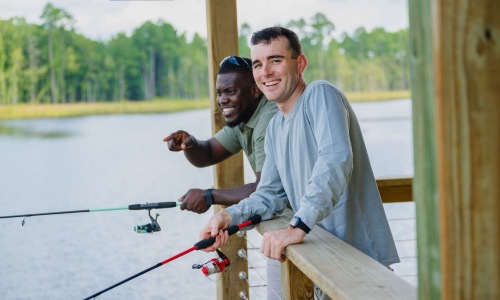 two men fishing off pier